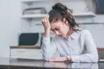 woman sitting at a table looking stressed