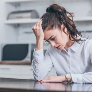 woman sitting at a table looking stressed