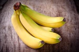 Stack of bananas sitting on a table.