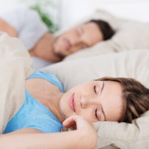 Young couple sleeping in bed having a restful sleep, closeup of the wife.